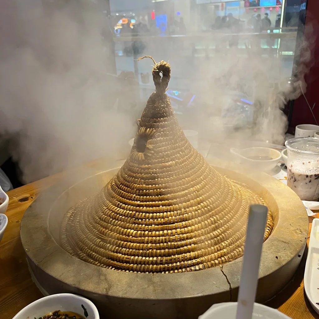 Jianshui Stone Pot Fish 地道建水石鍋魚,雲南特色料理。新鮮魚類以手工雕刻石鍋蒸製,覆蓋編織圓錐草蓋,熱氣騰騰。