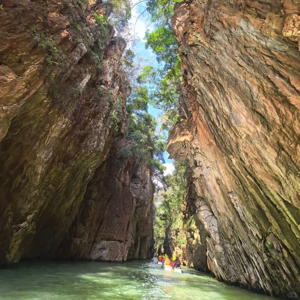 Jiuxiang Scenic Area3 遊客穿著黃色救生衣,乘船穿行於九鄉狹窄的蔭翠峽中,四周環繞著高聳且翠綠的峭壁。