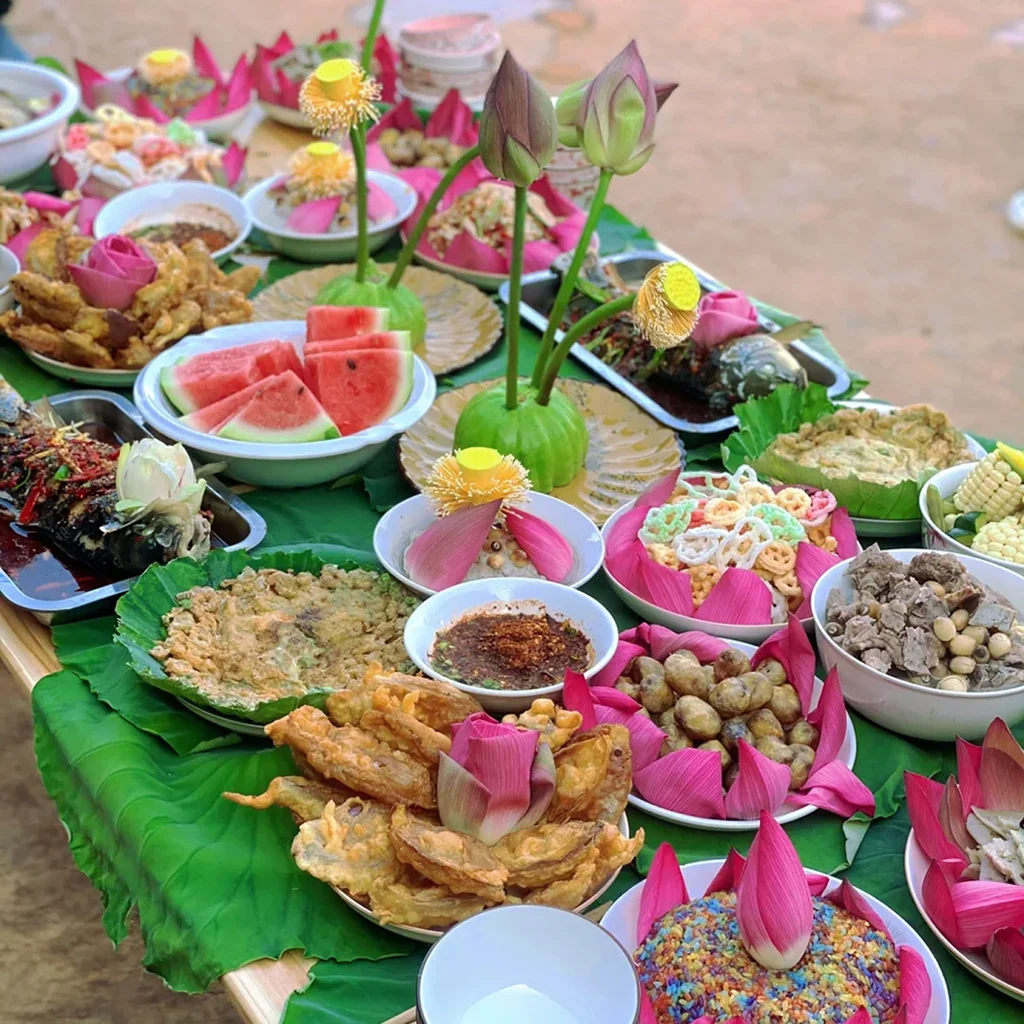 Lotus Banquet 普者黑木桌上鋪滿巨大的綠色荷葉,上方擺放著各式色彩繽紛的傳統特色料理。