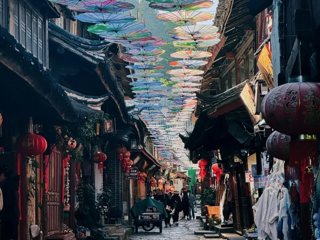 雲南麗江古城油傘街，五彩油傘鋪滿歷史石板巷，兩側是傳統納西建築與紅燈籠，遊客絡繹不絕。