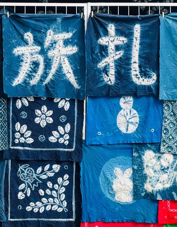 Bai tie dye craft Dali rlb2wiylrg4nkqnya457kj3209qbvv7dyw6t18d7nk 大理白族扎染工藝,藍染布料呈現傳統圖案與漢字,展現民族特色。