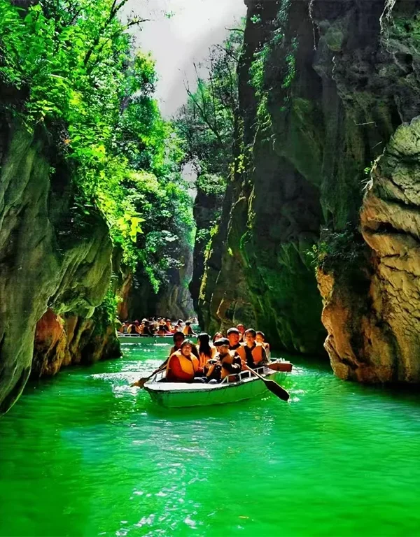 Jiuxiang Cuiyin Gorge 遊客乘船穿越昆明九鄉翠蔭峽,兩側為高聳石灰岩峽谷與翠綠水面。