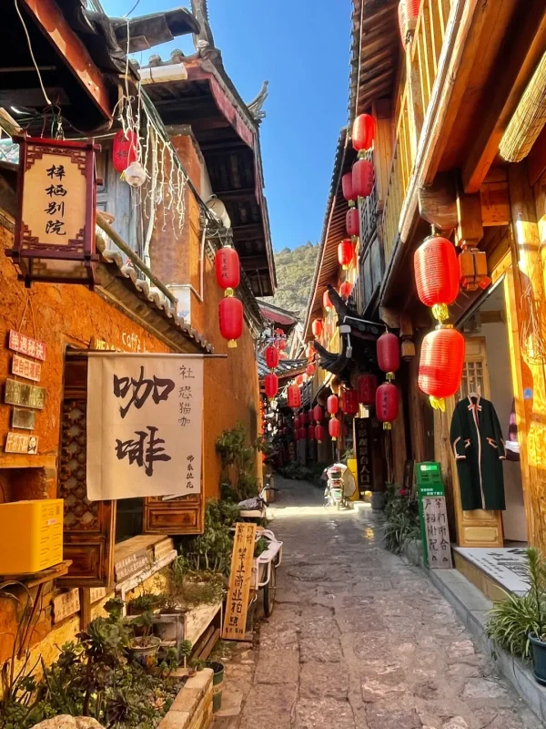 Shuhe Ancient Town Lijiang 1 束河古鎮的陽光古巷,紅燈籠高掛、木質建築溫暖,藍天下的青石板路,是麗江最具慢生活氛圍的巷弄畫面。