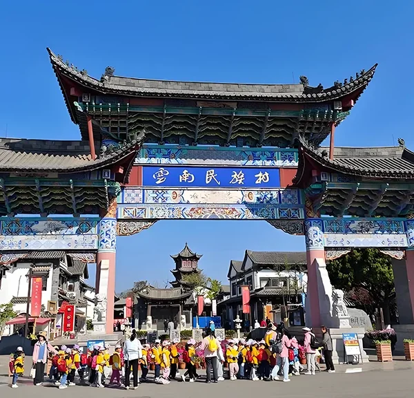 Yunnan Ethnic Village 雲南民族村入口牌樓,傳統建築與遊客活動交織,展現文化氛圍。
